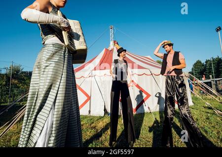 Artistes masculins et féminins debout avec des pilotis sur la prairie Banque D'Images