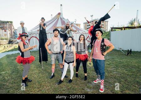 Des artistes de cirque heureux debout sur la prairie Banque D'Images