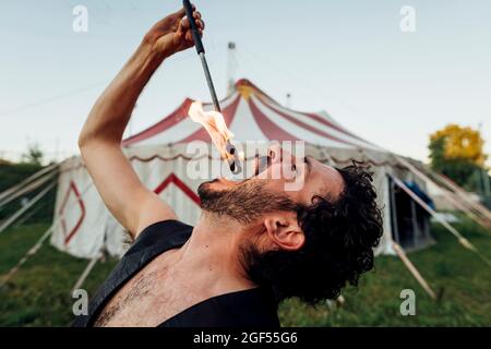 Homme pompier pratiquant à l'extérieur de la tente de cirque Banque D'Images