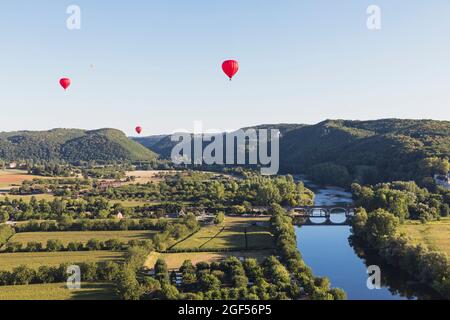 Ballons d'air chaud rouges volant contre un ciel clair au-dessus de la Dordogne Banque D'Images