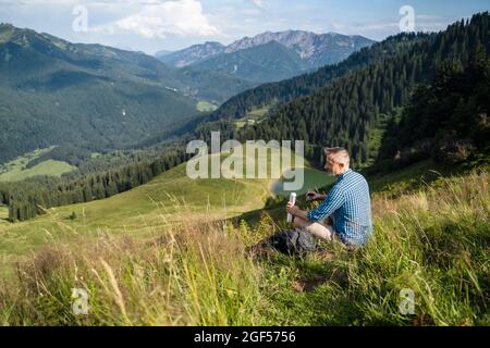 Randonneur mâle regardant la montagne pendant la journée ensoleillée Banque D'Images