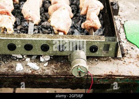 Shish kebab sur les brochettes à l'extérieur en gros plan. Brazier électrique avec brochettes tournantes. Banque D'Images