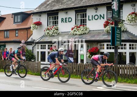 Les cyclistes qui participent à la course sur route Victor Berlemont Trophy 2021 autour de Woodcote dans l'Oxfordshire passent devant la maison publique Red Lion à Woodcote Banque D'Images