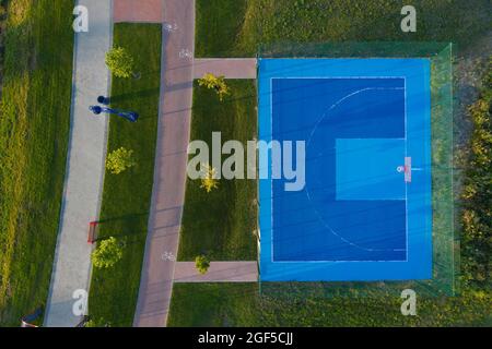 Vue depuis le drone sur le terrain de basket-ball avec revêtement bleu, gazon artificiel. Banque D'Images