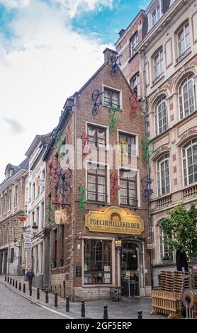 Bruxelles, Belgique - 31 juillet 2021 : façade du célèbre et emblématique pub Poechenellekelder et salle de musique avec vélos de couleur fixés au mur extérieur. Banque D'Images