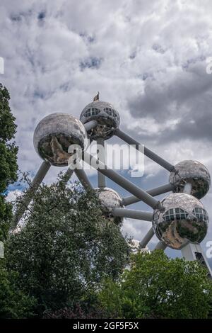 Bruxelles, Belgique - 31 juillet 2021 : partie supérieure de la statue de l'Atomium derrière un feuillage vert et sous un paysage bleu. Représente le cristal de fer. Banque D'Images