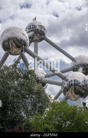 Bruxelles, Belgique - 31 juillet 2021 : partie de la statue de l'Atomium derrière un feuillage vert et sous un paysage bleu. Représente le cristal de fer. Banque D'Images