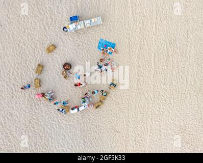 Vue aérienne d'un groupe de personnes à une plage d'océan ayant une fête Banque D'Images