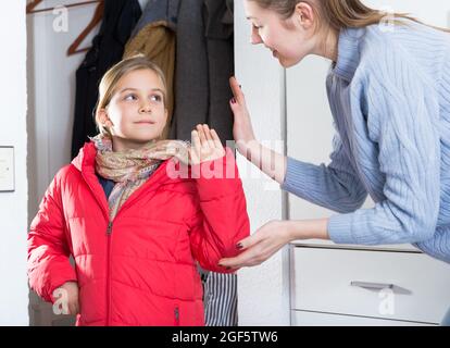 Mère dit au revoir à sa petite fille dans le couloir à la maison Banque D'Images