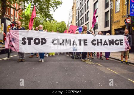 Londres, Royaume-Uni. 23 août 2021. Les manifestants tiennent une bannière « Stop Climate change » pendant la manifestation à Charing Cross Road. Extinction les manifestants de la rébellion se sont rassemblés dans le centre de Londres pour le début de leur campagne de deux semaines intitulée Impossible rébellion, appelant le gouvernement britannique à agir de manière significative sur la crise écologique et climatique. Crédit : SOPA Images Limited/Alamy Live News Banque D'Images