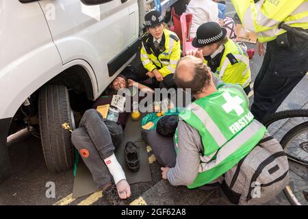 Londres, Royaume-Uni. 23 août 2021. Les policiers délèvent et arrêtent un manifestant qui s'est coincé sous une fourgonnette pendant la manifestation à Covent Garden.extinction Rebellion UK a lancé une manifestation à Covent Garden à Londres pour sensibiliser les gens aux problèmes du changement climatique, en exhortant le gouvernement à prendre des mesures. Des manifestants ont été vus s'affronter avec des membres de la police MET ( Metropolitan ) tout au long de l'année. Certains manifestants se sont enfermés sous des fourgonnettes et ont refusé de quitter l'espace. (Photo de Belinda Jiao/SOPA Images/Sipa USA) crédit: SIPA USA/Alay Live News Banque D'Images