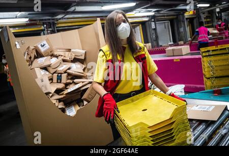 19 août 2021, Baden-Wuerttemberg, Köngen: Adriana TEC, répartiteur au centre de colis DHL à Köngen, place des colis sur une ligne de montage pendant son quart de nuit (à dpa: "Grand volume de colis au centre de distribution DHL - Corona or Not") photo: Christoph Schmidt/dpa Banque D'Images