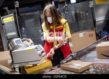 19 août 2021, Baden-Wuerttemberg, Köngen: Adriana TEC, répartiteur au centre de colis DHL à Köngen, lit les codes-barres sur les colis pendant son quart de nuit. (À dpa: 'Grand volume de colis au centre de distribution DHL - Corona or Not') photo: Christoph Schmidt/dpa Banque D'Images