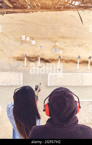 Femme libérant le stress, instructeur aidant la femme avec le pistolet Banque D'Images