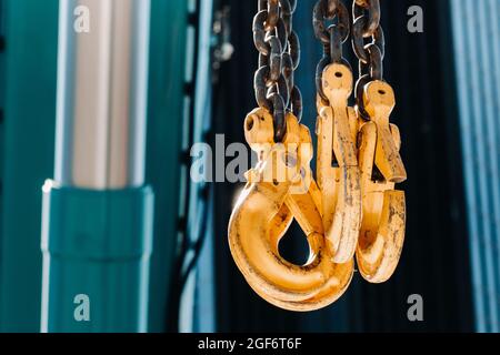 Les crochets de la grue mobile près de la vitre de bâtiments élevés.beaucoup de crochets suspendus à des chaînes suspendues à une grue. Banque D'Images