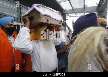 Les membres de Sikh riligion portent 3 Saroops de Sri Guru Granth Sahib, l'écriture sacrée à T3, aéroport IGI à New Delhi, Inde, le 24 août 2021. Photo par Anshuman Akash/ABACAPRESS.COM crédit: Abaca Press/Alay Live News Banque D'Images