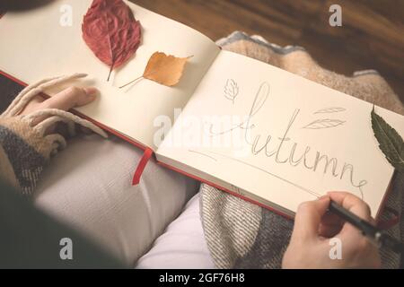 Scène d'automne ou d'automne. Carnet avec texte écrit à la main d'automne, feuilles sur papier. Arrière-plan hygge Banque D'Images
