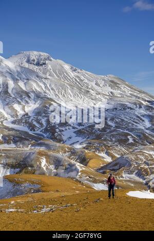 Femme en face des montagnes enneigées Fannborg et Snaekollur dans la région de source chaude Hveradalir, Kerlingarfjoell, Suourland, Islande Banque D'Images