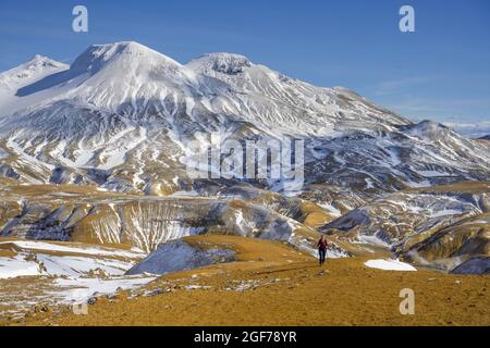 Femme en face des montagnes enneigées Fannborg et Snaekollur dans la région de source chaude Hveradalir, Kerlingarfjoell, Suourland, Islande Banque D'Images