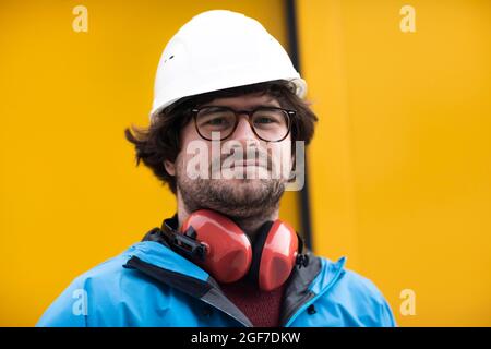 Jeune ingénieur équipé d'un casque et d'une protection auditive sur un site de travail à l'extérieur, Fribourg, Bade-Wurtemberg, Allemagne Banque D'Images