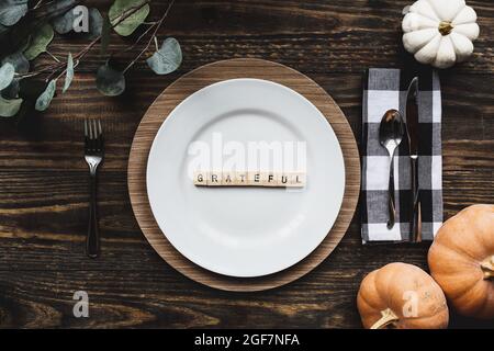 Thanksgiving placez le décor avec une assiette, serviette, sur une table décorée de plan de la position plate ou vue de dessus. Reconnaissant orthographié avec le bois de bloc laisser Banque D'Images