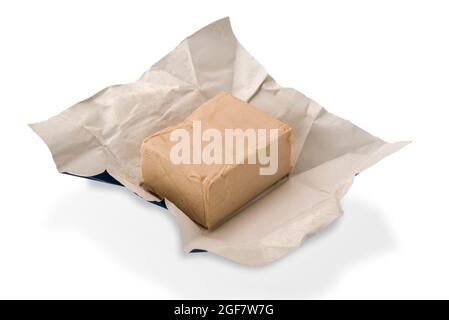 cube de levure fraîche, levure de bière dans du papier isolé sur fond blanc Banque D'Images