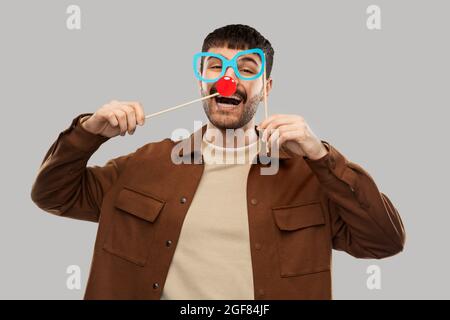 homme souriant heureux avec des lunettes et un nez clown rouge Banque D'Images