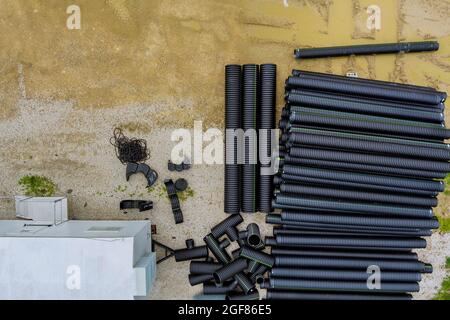 Tuyau en polyéthylène empilé de pile en plastique noir temporairement dans un nouveau bâtiment de construction Banque D'Images