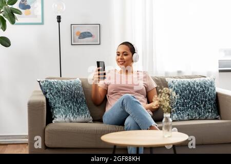 femme avec un smartphone qui écoute de la musique à la maison Banque D'Images
