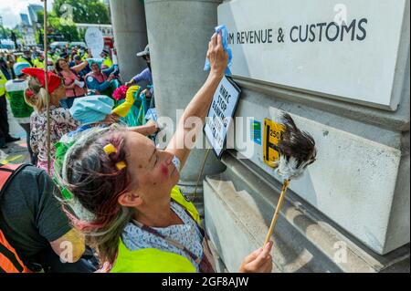 Londres, Royaume-Uni. 24 août 2021. Les femmes de ménage arrivent pour nettoyer le bâtiment - XR Cymru manifestations devant HM Revenue and Customs sur Whitehall au sujet de l'implication des gouvernements dans les industries des combustibles fossiles et aussi Barclays record des financer - extinction la rébellion commence deux semaines de protestation, sous le nom de l'impossible rébellion, à Londres. Crédit : Guy Bell/Alay Live News Banque D'Images