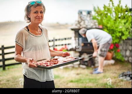 Soirée barbecue. Des amis heureux ayant une partie barbecue arrière-cour, griller de la viande, boire et se détendre pendant une journée ensoleillée à l'extérieur Banque D'Images