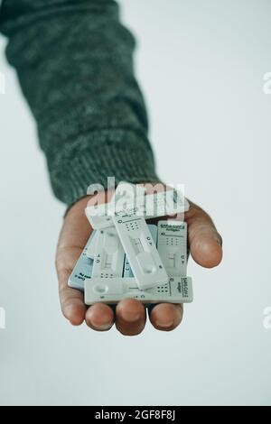 gros plan d'un jeune homme ayant une poignée de dispositifs de test diagnostique d'antigène covid-19 dans sa main Banque D'Images