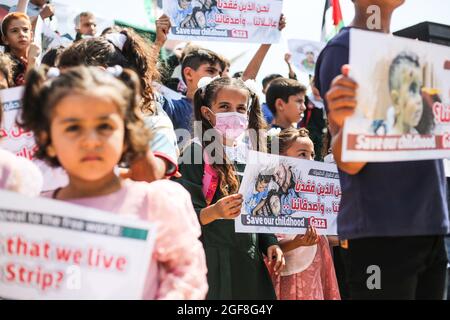 Gaza, Palestine. 24 août 2021. Des enfants palestiniens brandissent des banderoles au cours d'un événement pour envoyer des messages humanitaires au monde afin de mettre fin au siège de Gaza par Israël. (Photo par Ahmed Zakot/SOPA Images/Sipa USA) crédit: SIPA USA/Alay Live News Banque D'Images