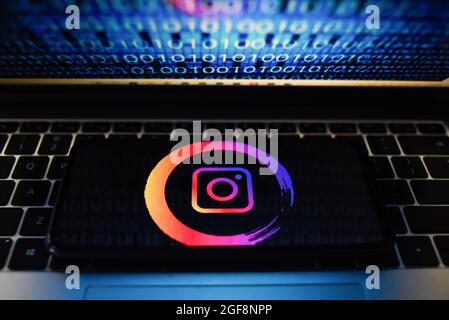 Portugal. 24 août 2021. Sur cette photo, un logo Instagram apparaît sur un smartphone avec un code binaire sur l'écran d'un ordinateur portable. Crédit : SOPA Images Limited/Alamy Live News Banque D'Images