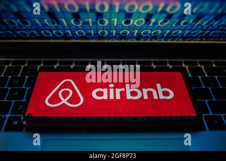Portugal. 24 août 2021. Sur cette photo, un logo Airbnb apparaît sur un smartphone avec du code binaire sur l'écran d'un ordinateur portable. (Photo par Omar marques/SOPA Images/Sipa USA) crédit: SIPA USA/Alay Live News Banque D'Images