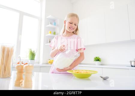 Photo de jeune fille gaie heureux sourire positif déjeuner manger croustillant muesli laiterie saine alimentation à l'intérieur Banque D'Images