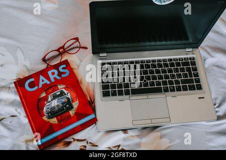 IASI, ROUMANIE - 12 juillet 2018: Une vue de dessus du livre "Cars" de Matt Leonard, une paire de lunettes et un ordinateur portable HP Banque D'Images