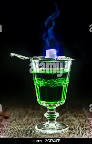 coupe classique à base d'absinthe avec cuillère en métal et mélange de sucre flamme bleue Banque D'Images
