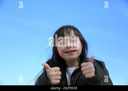 Portrait of little girl smiling sur fond de ciel bleu les Banque D'Images