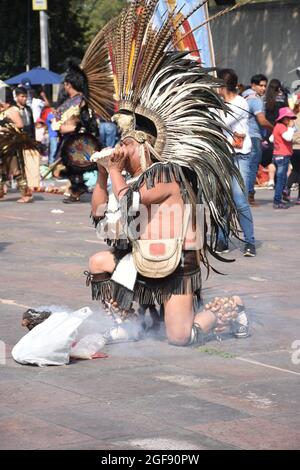 Les autochtones, appelés Concheros, sont vêtus de vêtements traditionnels pour un pèlerinage à la Villa Guadalupe à Mexico. Ici, un homme joue un conch. Banque D'Images