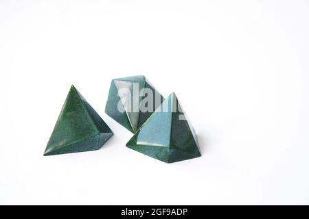 Bonbon de chocolat en forme de pyramide de luxe. Trois chocolats - couleur verte et motif géométrique triangulaire de bonbons. Travail fait à la main. Bonbons isolés sur blanc Banque D'Images