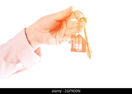 La main de la femme tient la clé de l'appartement, isoler sur un fond blanc Banque D'Images