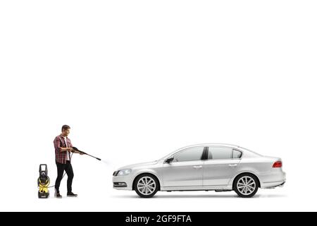 Photo en longueur d'un homme lavant une voiture argentée avec une machine à laver à pression isolée sur fond blanc Banque D'Images