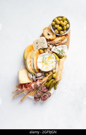 Plateau de fromages avec différents fromages, raisins, miel. Table de hors-d'œuvre avec en-cas d'antipasti. Vue de dessus, plan d'appartement Banque D'Images