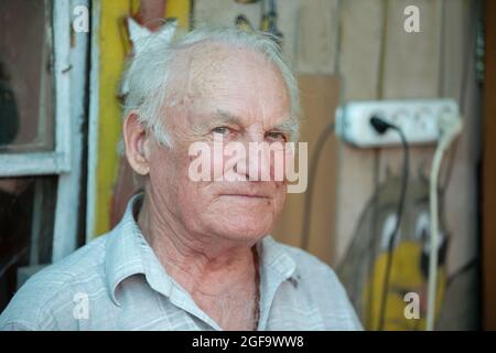 Beau homme âgé aux cheveux gris regardant la caméra. Gros plan du pensionné. Banque D'Images
