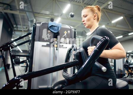 Une femme est engagée dans la forme physique dans la salle de gym pour perdre du poids et brûler des calories supplémentaires, un mode de vie sain, de sorte qu'il ya un corps mince. Banque D'Images