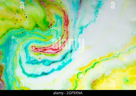 Fond coloré multicolore de peintures jaunes et vertes sous forme de vague recouverte de sparkles dorés. Banque D'Images