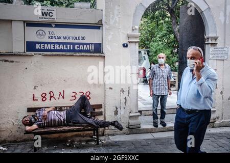 Izmir, Konak, Izmir. 24 août 2021. Entrée de la mosquée historique Kemeralti dans le quartier de Konak, Izmir-Turquie. Un homme qui se nappent sur un banc, et des gens qui marchent dans la rue. (Image de crédit : © Uygar Ozel/ZUMA Press Wire) Banque D'Images