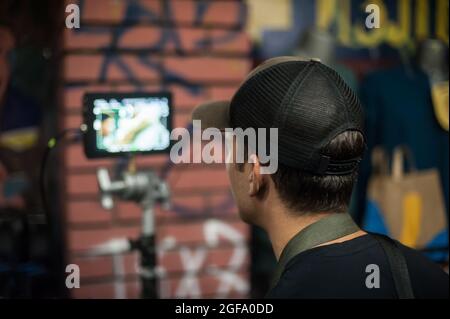 Dans les coulisses. Le réalisateur supervise et contrôle le tournage du film sur l'écran lcd depuis le studio de montage de film extérieur. Analogique a Banque D'Images