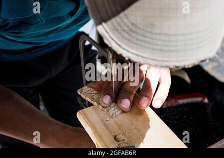 Homme faisant de l'art sur bois. Street Art. Gros plan de l'homme faisant de l'artisanat à Buenos Aires, Argentine. Banque D'Images